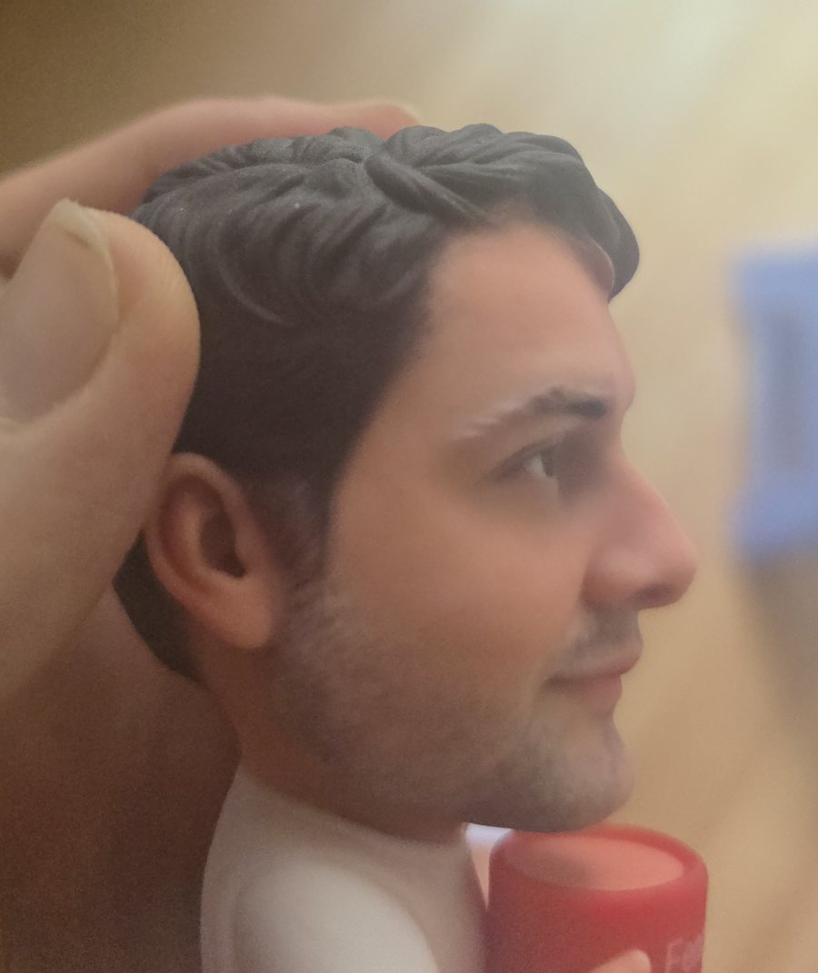 Figurenkopf im Profil mit fein ausgearbeiteten Haarsträhnen und Ohr